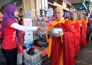 Une musulmane offre l'aumône à un moine bouddhiste